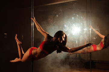 Obraz na płótnie Canvas young hot woman in sexy lingerie performs sensual pole dance. Go-go dancer