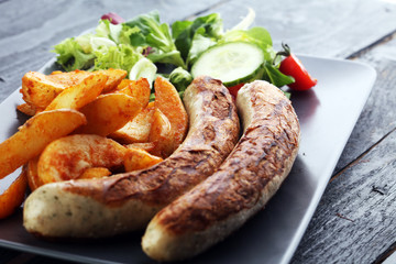 grilled sausages and potatoes and salad