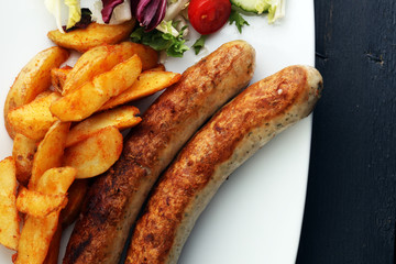 grilled sausages and potatoes and salad