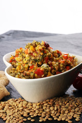 Lentil with carrot and pumpkin ragout in a wooden bowl on a wood