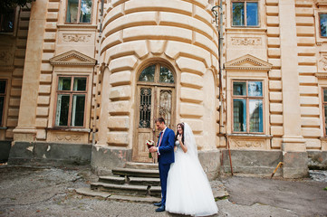 Obraz premium Wedding couple in love stay against old vintage palace.