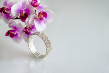 Zirconium bracelet lies on the background of purple orchids