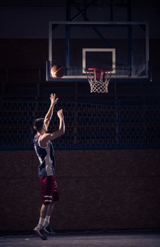 Basketball player shooting, indoors court