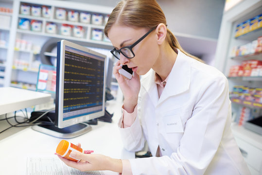 Female Pharmacist Advising By The Phone Call .