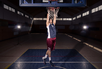 one basketball player in air slam dunk, basketball court indoors