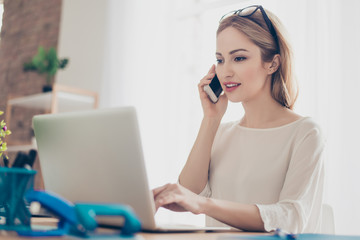 Happy cute pretty manager talking on mobile phone with client