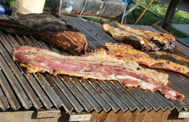 grilled meat in a food stall on the street with bacon and cooked