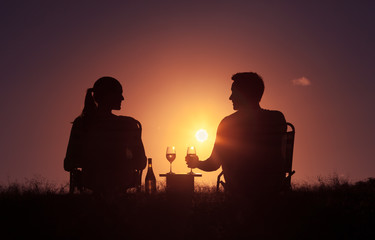 Fototapeta na wymiar Happy couple enjoying a beautiful sunset and a glass of wine. 