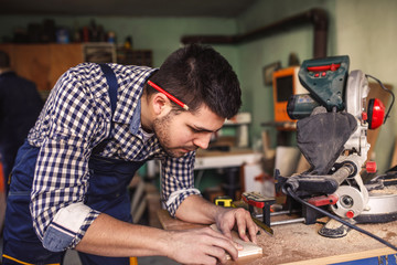 Handsome carftsman working in a work shop.