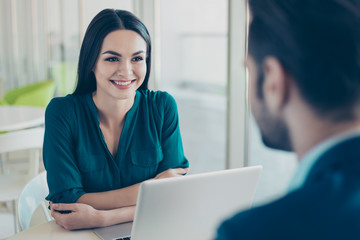 Young woman listening to her future colleague about new job in financial sphere