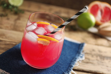 Refreshing cocktail with grapefruit on wooden table