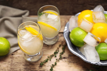Refreshing cocktails with lemon on wooden table