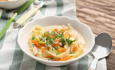 Chicken noodle soup in plate on table