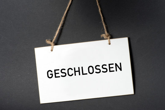 Ein weisses Schild mit dem Aufdruck Geschlossen