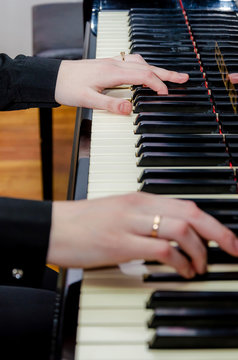 Hands play the piano keys. Concert in music school
