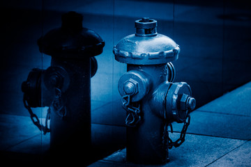 detail shot of fire hydrant against wall in blue tone.