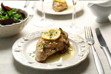 Plate with delicious chicken breast on served table
