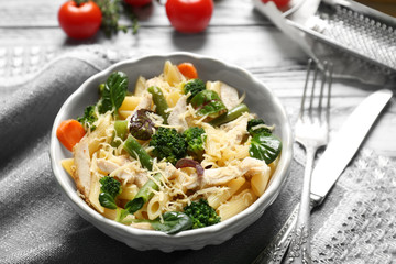Bowl with tasty chicken and noodles on table