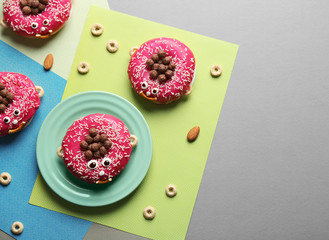 Funny decorated donuts on table