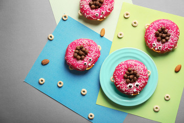 Funny decorated donuts on table