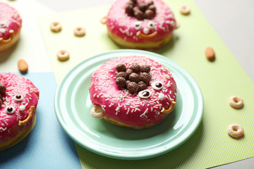 Funny decorated donuts on table