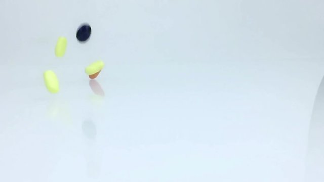 medical, vitamins, food supplement pills falling in slow motion on white background, health care diet concept