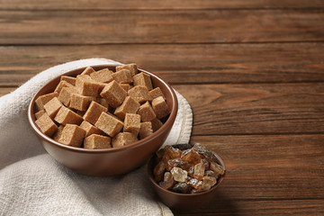 Brown sugar in bowls on wooden background