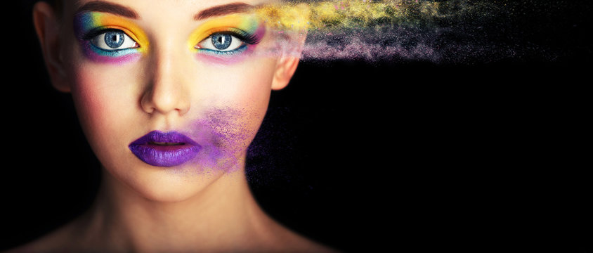 Fashion model girl portrait with colorful powder make up. Beauty woman with bright color makeup. Close-up of Vogue style lady face, Abstract colourful make-up, Art design. Black background. copy space