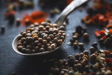 Spoon with spices coriander on chalkboard