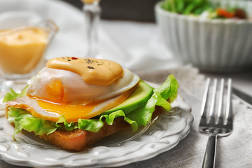 Tasty egg Benedict on plate, closeup