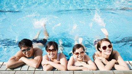 Happy family playing in swimming pool