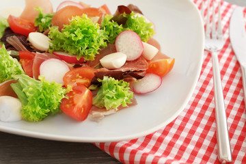 Plate with fresh salad on table, closeup