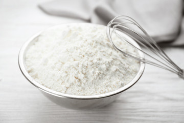 Bowl full of white wheat flour on wooden kitchen table