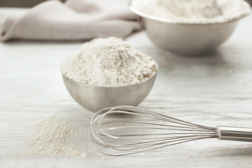 Bowl full of white wheat flour on wooden kitchen table