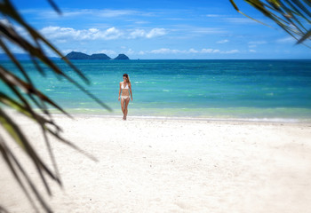 Fototapeta na wymiar Beautiful young woman on a paradise tropical beach