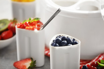 Cup with tasty homemade yogurt and berries, closeup