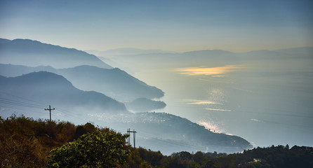 Highlands with volcanoes at Lake Atitlan in Guatemala / Foggy morning at lake in Guatemala in the morning hours