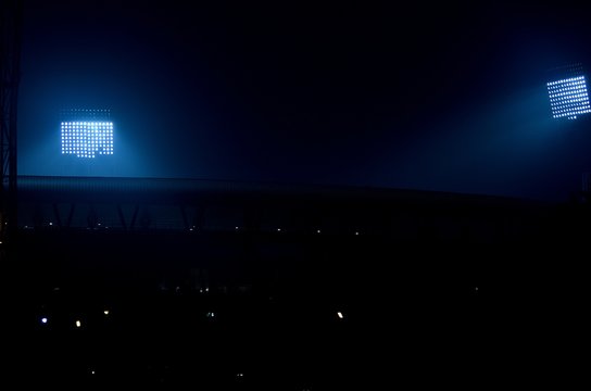 Stadium floodlights against a dark night sky background.