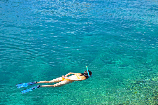 Woman snorkeling in crystal clear tropical water