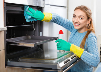 Cheerful smiling adult girl  removing snuff in oven