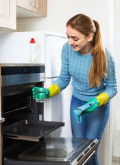 Cheerful smiling glad adult girl removing snuff in oven