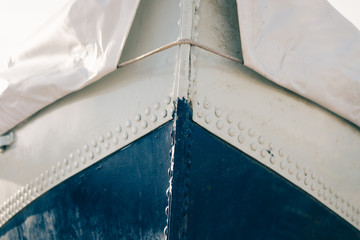 Cropped image of a metal boat covered with tarpaulin