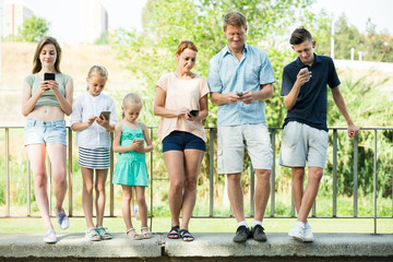 Family with kids playing with mobile phones