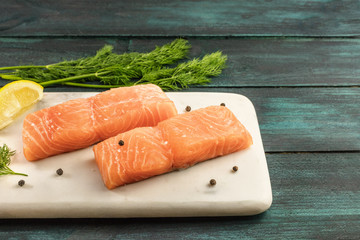 Two slices of salmon on dark background with copyspace