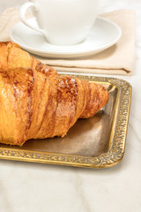 Fresh croissants on vintage tray, with copyspace