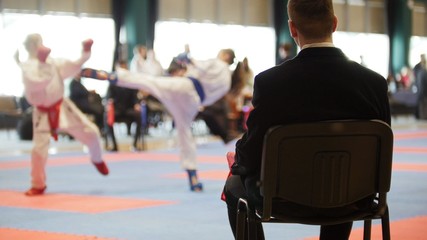 Martial art competitions- karate - judge coaches looking at female teenager's karate fighting © KONSTANTIN SHISHKIN