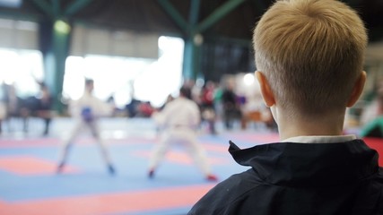 Karate championship - teenager boy looking at karate fighting - spectator at competition