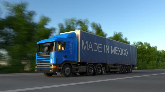 Speeding freight semi truck with MADE IN MEXICO caption on the trailer. Road cargo transportation. Seamless loop 4K clip