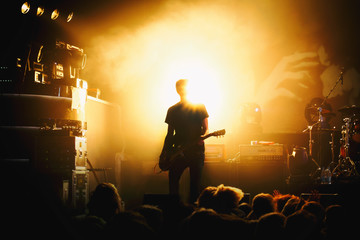 silhouette of guitar player in action on concert stage