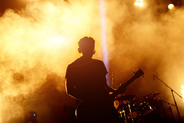 silhouette of guitar player in action on concert stage